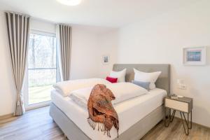 a bedroom with a large bed with a large window at Terrassenwohnung "Haffromantik" in Garz +16 photos