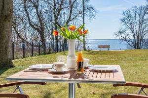 a picnic table with a vase of flowers on it at Terrassenwohnung "Haffromantik" in Garz