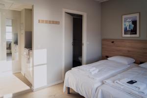 a bedroom with two beds and a mirror at HOTEL SØMA Ilulissat in Ilulissat
