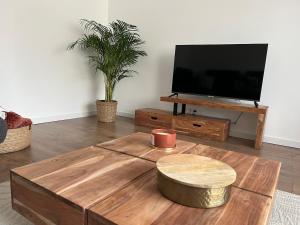 a living room with a coffee table and a flat screen tv at Durbuy, l Olivier, Maison charmante 4 façades en pierre du pays in Durbuy