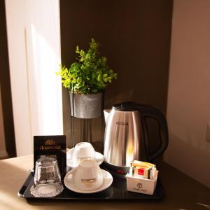a table with a coffee maker and a vase with a plant at Doanesia Premium Hotel & Spa in Tirana