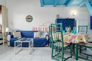 a living room with a blue couch and a table at La Bouganville in Porto Rotondo