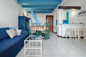 a living room with a blue couch and a table at La Bouganville in Porto Rotondo
