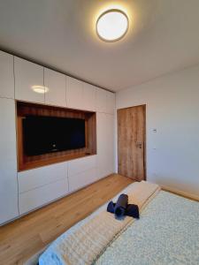 a room with a large bed with a flat screen tv at Big Balcony & Free parking - PREMIUM Apartment in Bratislava