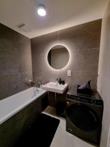 a bathroom with a sink and a washing machine at Big Balcony & Free parking - PREMIUM Apartment in Bratislava