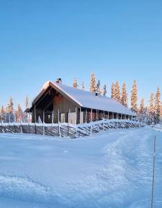a building covered in snow next to a snow covered field at Cabin Lillehammer, Nordseter, Sjusjøen in Lillehammer
