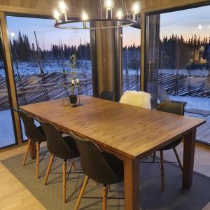 a dining room table with chairs and a large window at Cabin Lillehammer, Nordseter, Sjusjøen in Lillehammer +44 photos