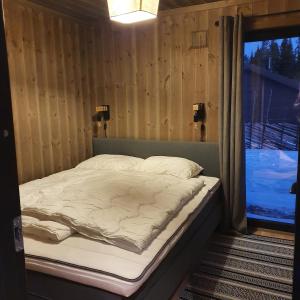 a bed in a room next to a window at Cabin Lillehammer, Nordseter, Sjusjøen in Lillehammer