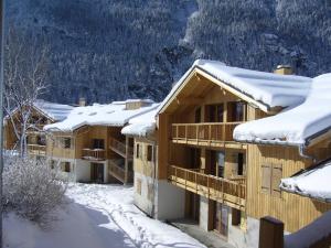 un edificio ricoperto di neve con tetti ricoperti di neve di Hameau 4 106 - SPA & PISCINE appartement 6 pers a Orelle
