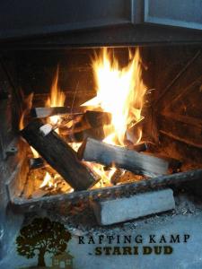 a fire in a grill with logs in it at Rafting Campsite Stari Dud in Foča