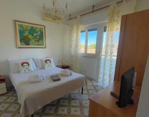 a bedroom with a bed and a tv and a window at FELYX APARTMENT - Bright, Spacious, and 100 mt from the waves - Lavinio Mare in Anzio