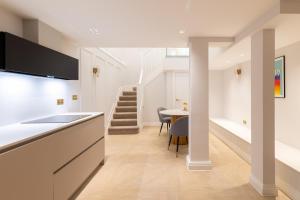 a kitchen with white counters and a table with chairs at Stay Kula London Bridge in London