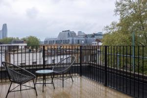 a balcony with two chairs and a table at Stay Kula London Bridge in London