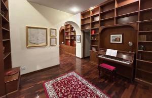 a living room with a piano in a library at Colosseum's Custodian - Apartment 115 m2 in Rome +25 photos