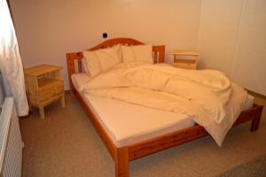 ザンクト・ミヒャエル・イム・ルンガウにあるApartment Lungauのベッドルーム1室(白いシーツが備わる木製ベッド1台付)