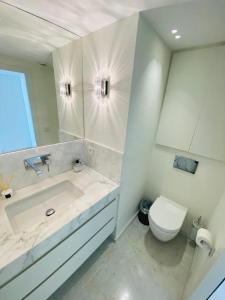 a white bathroom with a sink and a toilet at GRAY D ALBION Residence in Cannes +10 photos