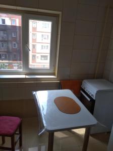a room with a table and a stove and a window at inchiriez 2 camere in ap cu 3 camere citeste si la despre gazda in Lugoj
