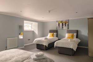 a bedroom with two beds with yellow pillows at Elrick Estate - Little Elrick in Newmachar
