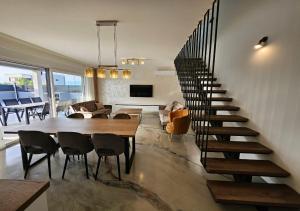 a living room with a staircase and a table and chairs at Vila OASIS - Zadar, Vrsi in Vrsi