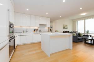 a kitchen with white cabinets and a living room at Cozy 3BR High Rise with Pool with great views in Los Angeles