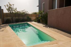 a swimming pool in front of a house at Villa Merlin in Galatás