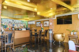 a restaurant with a bar and chairs in a room at GOYA hotel in Chiang Mai