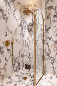 a bathroom with a shower with a marble wall at Stay Kula London Bridge in London +39 photos