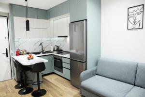 a kitchen with a couch and a table and a refrigerator at Dream House Enia 4 in Shkodër