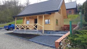 a small wooden house with a gambrel roof at Domek u Pusi z jacuzzi in Solina