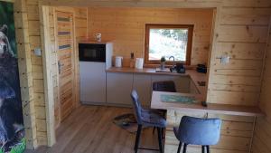 a kitchen in a log cabin with a table and chairs at Domek u Pusi in Solina