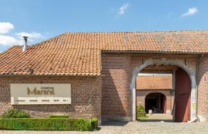 a brick building with a sign that reads brass mariani at Domein Marsnil in Heers