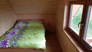 a bed in a small room with a window at Domek u Pusi in Solina