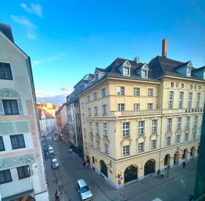 a large yellow building on a city street at Marienplatz Design Apartment - Historic Center in Munich
