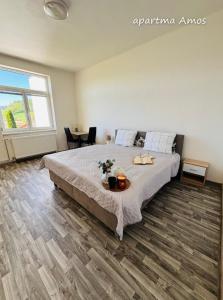 a bedroom with a bed and a table with flowers on it at Apartmány Komenského Velké Losiny in Velké Losiny
