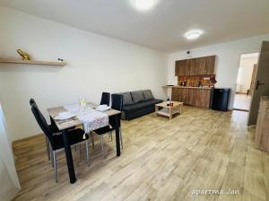 a living room with a table and a couch at Apartmány Komenského Velké Losiny in Velké Losiny