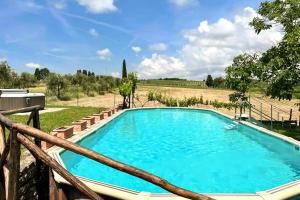 a blue swimming pool in a field with a fence at Casalino in Castelnuovo Berardenga +30 photos