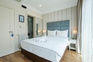 a bedroom with a large white bed with a blue headboard at Ten Rooms Istanbul Hotel in Istanbul