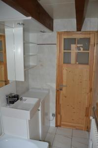 ein Badezimmer mit Toilette und Waschbecken und einer Tür in der Unterkunft Le Nid du Lac, appartement en duplex au bord du lac d'Annecy, résidence avec plage privée in Doussard