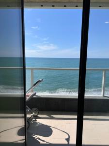 a view of the ocean from a room with a chair at Bamboo Beach Tsikhisdziri in Tsikhisdziri