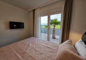a bedroom with a bed and a window with a palm tree at Vila OASIS - Zadar, Vrsi in Vrsi +15 photos