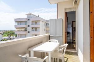 a white table and chairs on a balcony with a building at La casa di laura in Lido Adriano