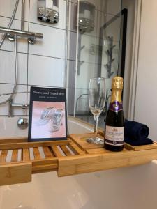 eine Flasche Wein und ein Glas auf einem Holztablett in der Unterkunft Cosy central Bath pad in Bath