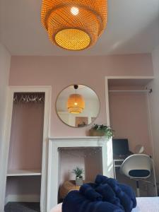 Zimmer mit einem Tisch, einem Spiegel und einer Lampe in der Unterkunft Cosy central Bath pad in Bath