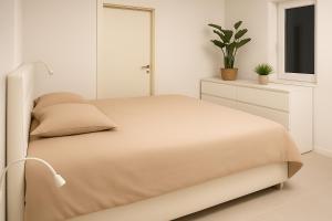 a white bedroom with a bed and a tv at Apartmaji ŽIVA in Blato