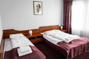 two beds in a hotel room with towels on them at Hotel Złoty Młyn Polichno in Polichno +20 photos