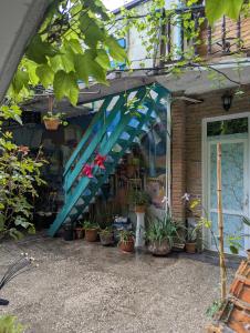 a store front with a blue awning and potted plants at Guest House Marina in Tbilisi City