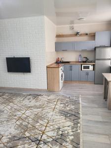 a large kitchen with a white brick wall at Квартира in Balqash