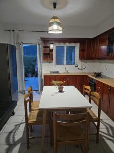 a kitchen with a white table and chairs and a table at Olives House in Keri