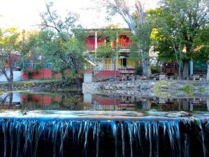 una cascada frente a un edificio con una casa en Hosteria Sans Souci in 