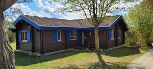 a wooden house with a blue roof at Ferienhaus Neckar 58 in Hayingen